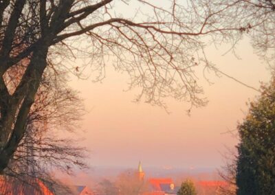 Zonsopkomst boven Ootmarsum met kerktoren en roze-oranje lucht gezien vanaf de Kuiperberg